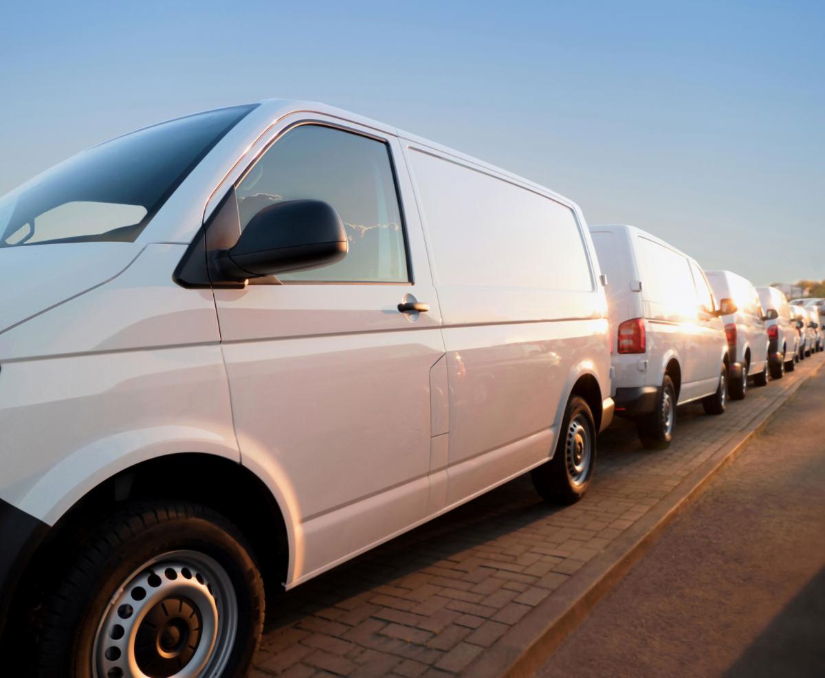 Row of white vans parked along a street